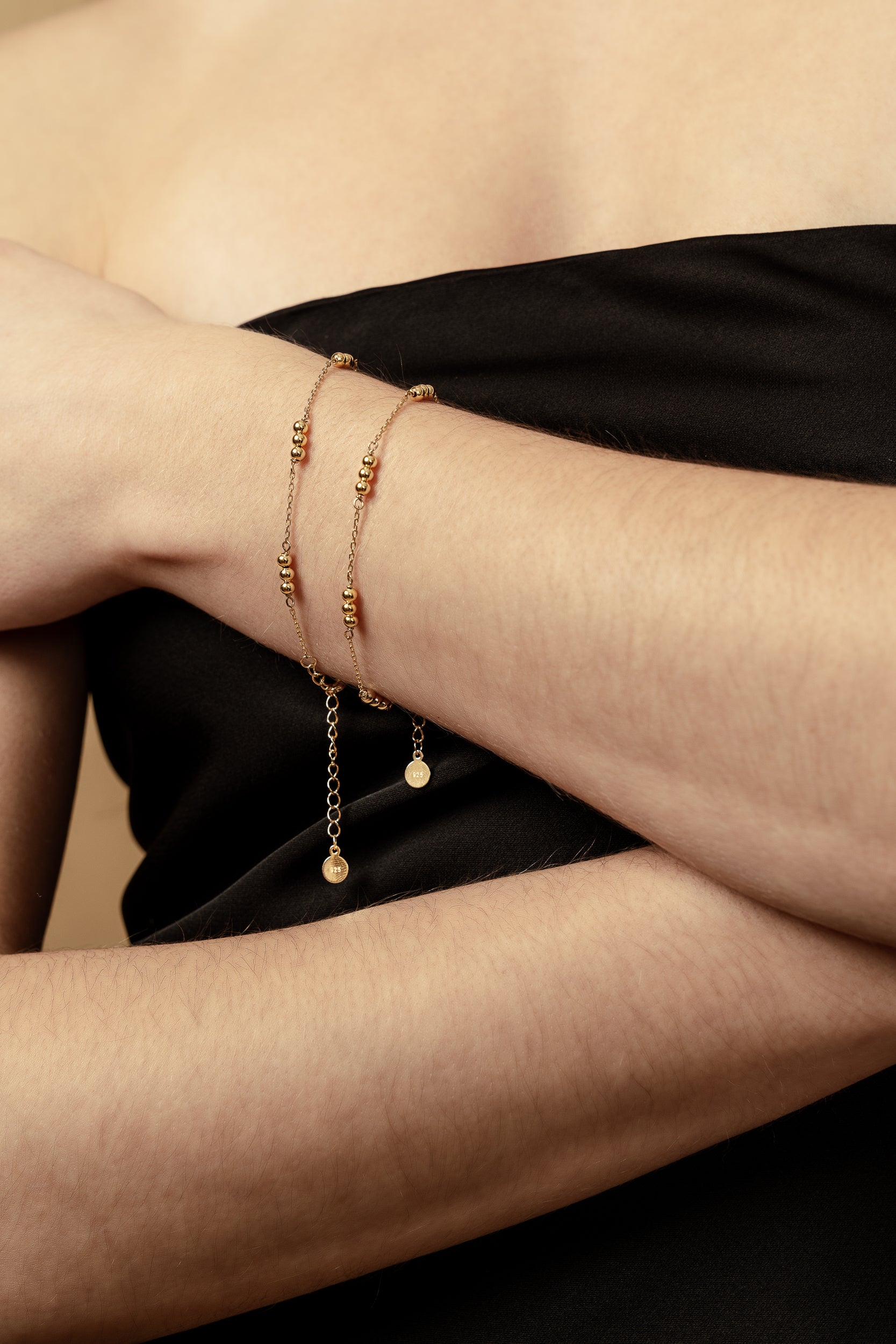 gold adjustable womans bracelet aega jewelry with small gold balls girl wearing two bracelets womans fashion little black dress