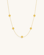 gold chain necklace with small flower pendants along the chain womans jewelry