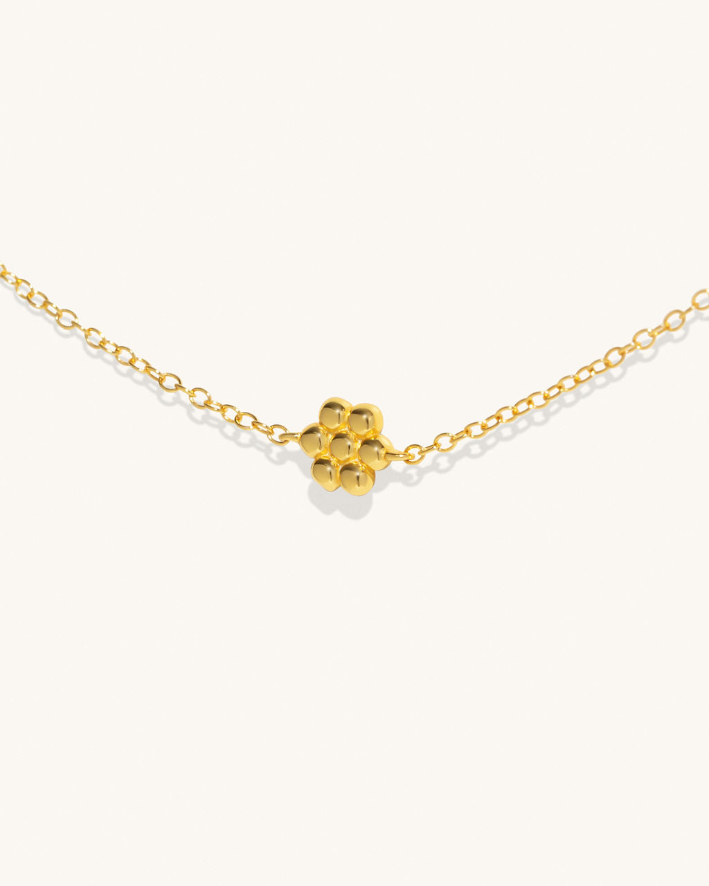 gold chain necklace with small flower pendants along the chain womans jewelry