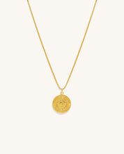 gold chain necklace with a coin pendant